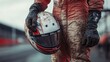 © Maria Vitkovska - Race car driver holding helmet covered in mud after race