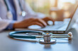 © oksa_studio - Doctor using laptop with stethoscope on desk in hospital