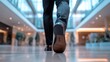 © Thanos - Close-Up of Businessman's Shoes and Pant Leg Walking in Office Building, Golden Hour Lighting