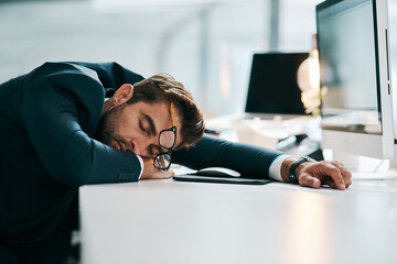 Wall Mural - Business, man and sleeping on computer at office with burnout or tired with research for project deadline. Male person, employee and exhausted or tired with overtime, overworked and fatigue on desk