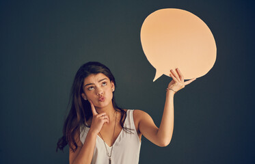 Thinking, woman and speech bubble with news in studio for presentation feedback, opinion sign and planning launch. Girl, poster and announcement information for advertising, vote and dark background