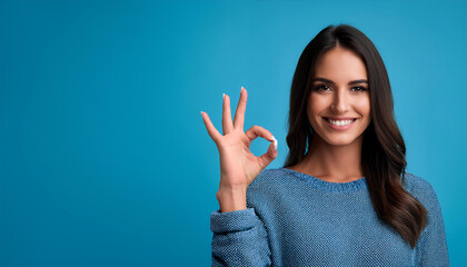 portrait beautiful young woman making okay sign blue background