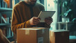 © The Stock Photo Girl - A person checking a tablet while surrounded by cardboard boxes in a cozy indoor setting.