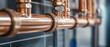 © The Stock Photo Girl - Close-up of copper plumbing pipes with fittings and seals, indicating plumbing infrastructure.