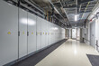 © alhim - The interior of an electrical equipment room features neatly arranged cabinets, warning signs, and a cooling system, emphasizing safety and organization in a utility space.