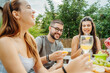 © Dusan - Group of three friends or family having picnic in backyard or garden
