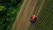 © วรวิทย์ ทรงพลยศ - Aerial view of tractor planting crops in lush green farmland with rows of plants