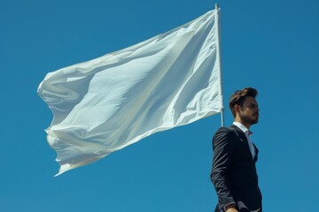 Businessman holding white flag under blue sky