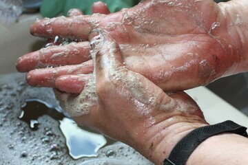 man washing dirty hands at sink with soap lather