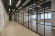 © alhim - The working floor of an office building. Glass partitions separate the open space with .panoramic windows.