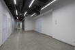 © alhim - An empty office corridor with many doors, in a large corporate building.