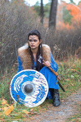 Viking warrior girl in blue in autumn