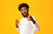 © Prostock-studio - Excited black guy indicating at camera, happy to see someone, orange studio background