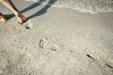 Wall Mural - A Feet and footprints by the seashore in nature travel vacation background