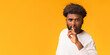 © Prostock-studio - Handsome silent african man making hush gesture, orange studio background