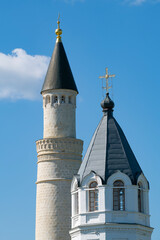 Wall Mural - Minaret of a medieval mosque and bell tower of the ancient Assumption church against the blue sky, Bolgar. Tatarstan