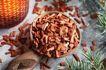 Wall Mural - Red sandalwood chips on a spoon with a candle