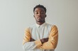 © Aksana - Confident young man in stylish shirt with arms crossed against neutral background, self-assured mood concept