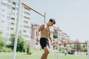 Wall Mural - Fit and strong male athlete exercising outdoors in a park. Demonstrating fitness, health, and dedication in an urban environment.