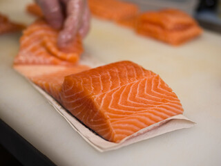 A beautiful piece of salmon rests on a kitchen board, showcasing its rich texture and color. This fresh salmon is ready for preparation, making it a delightful centerpiece for any dish.