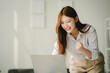 © Daenin - Beautiful Asian woman is very excited to close a sale. The young woman is smiling and happy about the successful project.