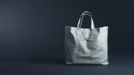 A chic tote bag in light gray leather, isolated on a dark background.