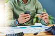 © SensSai/peopleimages.com - Credit card, hands and phone for fintech with person at desk in office for accounting or portfolio management. Bank payment, budget and finance with accountant in workplace for investment or savings