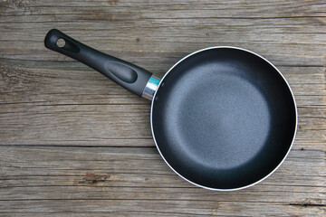 empty frying pan on wooden table top view