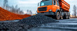 © khonkangrua - Freshly laid asphalt with a dump truck in the background, depicting a road construction site in progress.