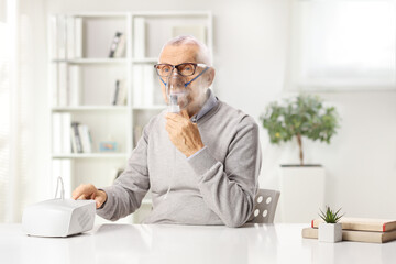 Man sitting at home and using a nebulizer