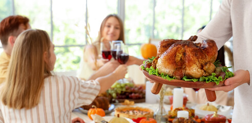 Sticker - Young man with turkey having dinner on Thanksgiving Day, closeup