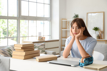 Canvas Print - Female student with books and laptop tired of studying at home