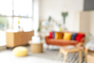 Wall Mural - Blurred view of stylish living room with red sofa, table and armchair