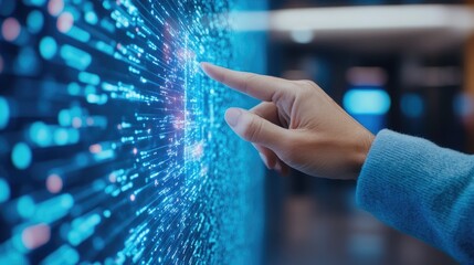 A hand touching a digital screen filled with glowing data particles, representing technology, innovation, and interaction.