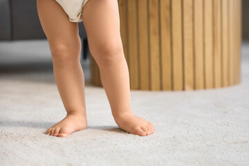 Poster - Cute baby girl learning to walk at home, closeup