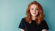© Sumet - Portrait of a young woman with red curly hair against a teal background, exuding confidence and warmth in a casual attire.
