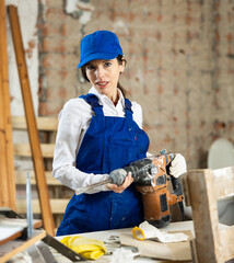 Wall Mural - Portrait of a female builder with an industrial puncher in her hands