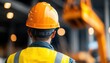 © Tonton54 - A construction worker in an orange helmet oversees a building site, showcasing safety and professionalism in the workplace.