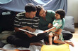 © Queenmoonlite Studio - Parents Teaching Kids, Father Reading Story on Books to Daughter and Son at Home