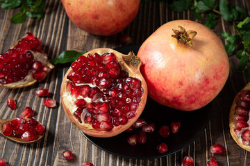 Wall Mural - open pomegranates, and pomegranate seeds on wooden table.