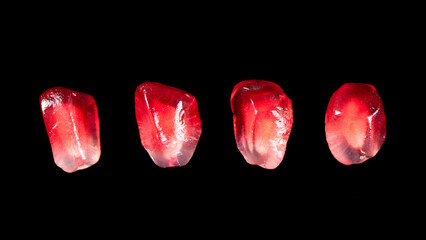 pomegranate seeds isolated on black background.