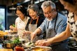 © kitipol - Middle-aged friends enjoying a hands-on cooking class, mixing ingredients and learning new culinary skills