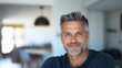 © Business Image - Serene middle-aged man with soft smile in modern home interior for lifestyle and wellbeing concepts