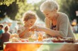 © kitipol - High-resolution brightly lit photorealistic candid photograph of a grandmother and grandchild enjoying a sunny afternoon at a community fair, playing games and tasting treats. The photograph is