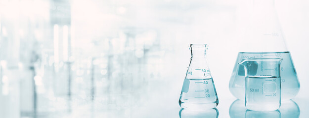 Wall Mural - flask and beaker with water in research science lab white banner background