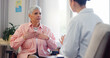 © WesLens/peopleimages.com - Doctor, consultation and elderly woman with chest pain for heart disease, advice and medical checkup. Healthcare, patient and worker with discussion for cardiac arrhythmia, palpitations and diagnosis