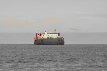 As the mountains stand tall in the port, the fishermen's boat sets sail.