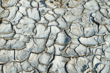 Gray cracked dry muddy ground closeup