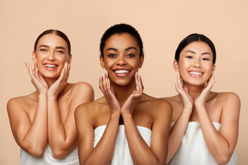 Wall Mural - Skincare Concept. Three Diverse Women Touching Face Caring For Perfect Skin Standing On Gray Background, Smiling To Camera