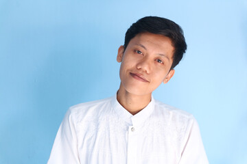 Smiling Asian young man looking at the camera wearing a white shirt